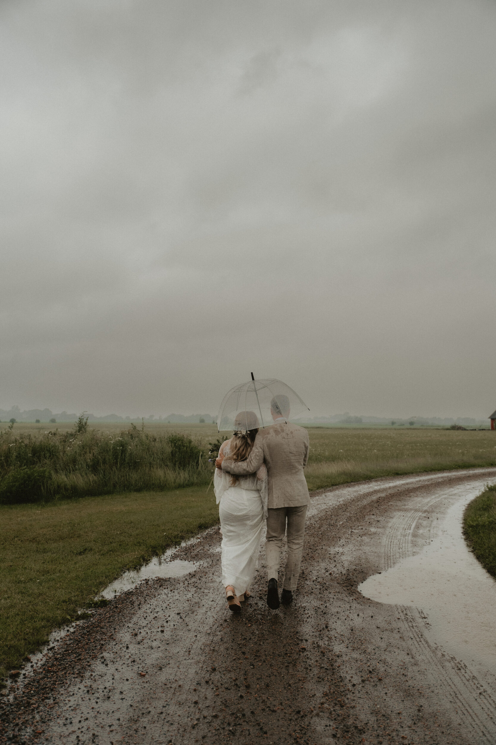 Porträtt av brudpar i regn, Fanny och Simon på Rönnås Lada